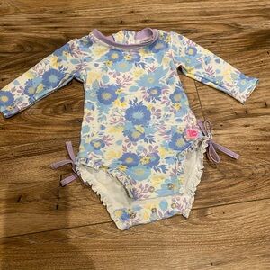 Never worn Ruffle butts one piece girls swimsuit 50spf. 3-6 months.